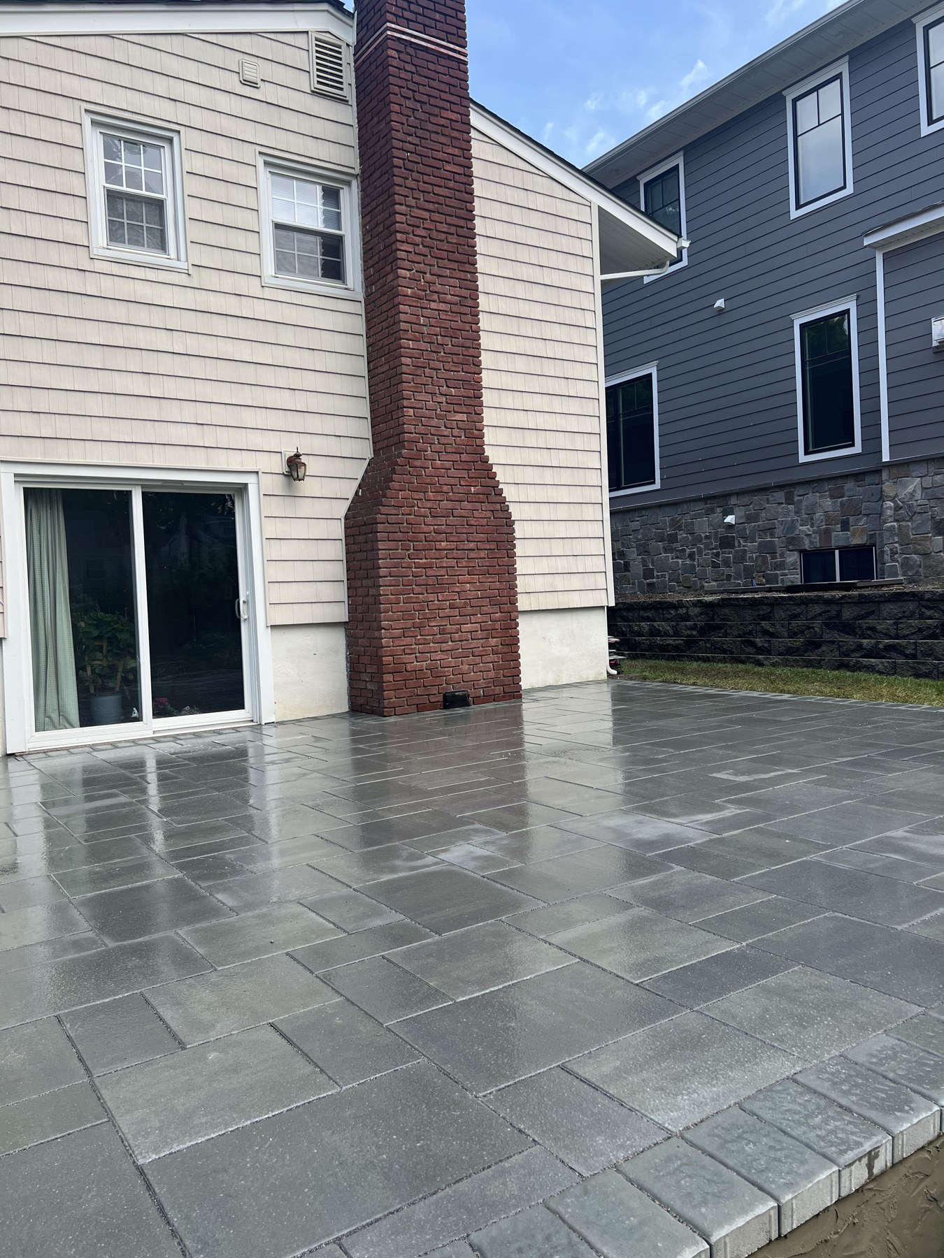 Stone tile patio beside a brick chimney